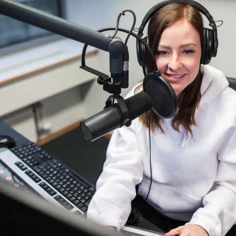 A student in a recording studio wearing headphones